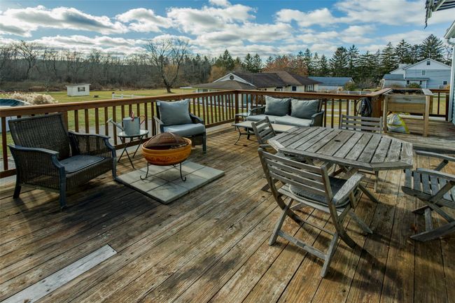 Wooden deck featuring a lawn, a shed, and an outdoor fire pit | Image 27