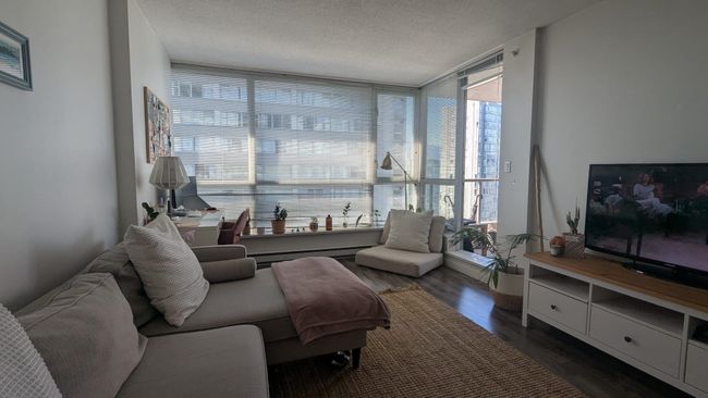Living area featuring floor to ceiling windows, wood finished floors, a textured ceiling, and a baseboard radiator | Image 5