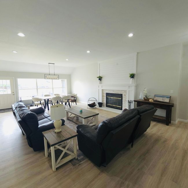 Living area featuring light wood-style floors, a glass covered fireplace, healthy amount of natural light, and recessed lighting | Image 4