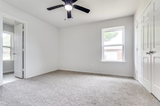 Unfurnished bedroom featuring light colored carpet, a ceiling fan, and a closet | Image 23