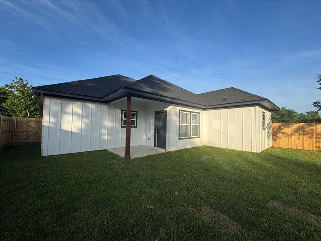 Rear view of property featuring a fenced backyard and roof with shingles | Image 25