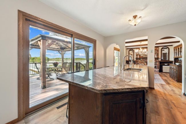 Main level full bathroom with a spacious vanity, tile floors, and elegant tile shower. | Image 19