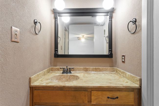 Bathroom with a textured wall, vanity, and ceiling fan | Image 28