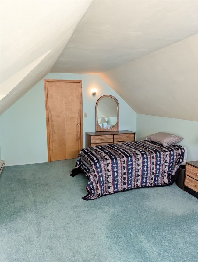 Carpeted bedroom with lofted ceiling | Image 12