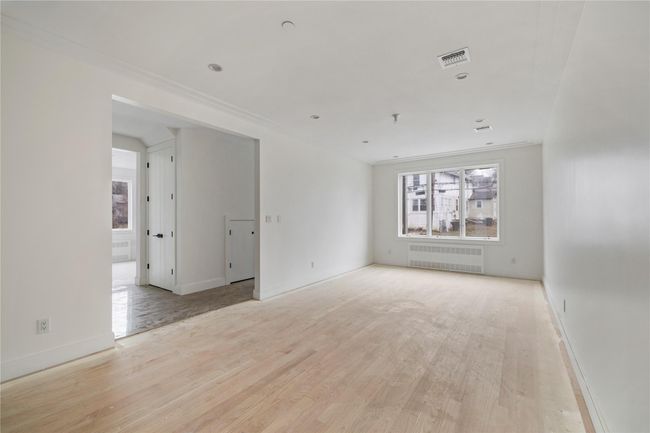 Spare room with radiator, baseboards, visible vents, and light wood finished floors | Image 13