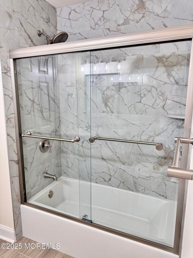 The shower and tub in the second full bath. Note the beautiful tile work! | Image 28