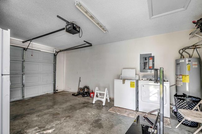 Garage with washing machine and dryer, electric water heater, electric panel, and a garage door opener | Image 37