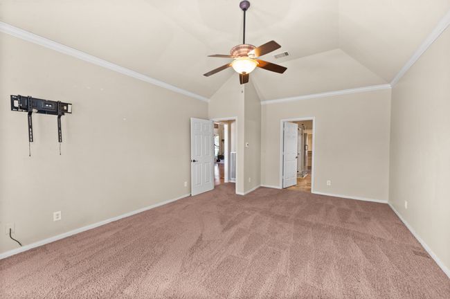 Unfurnished bedroom with carpet flooring, lofted ceiling, ornamental molding, and a ceiling fan | Image 16