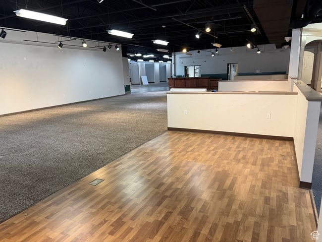 Interior space with rail lighting, open floor plan, baseboards, and wood finished floors | Image 21