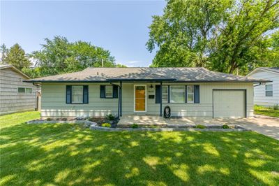 Ranch-style home with a porch, a garage, and a front yard | Image 1