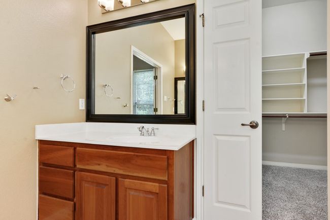 The spacious primary suite is a true retreat, complete with a luxurious bath featuring dual vanities, a walk-in shower, a soaking tub, and an oversized walk-in closet. | Image 26