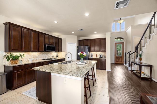 Beyond the entry is the large open kitchen concept with an oversized island. Cabinet lighting below and above and a walk-in pantry. Plenty of storage for your kitchen. | Image 11