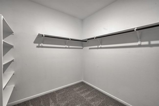 Spacious walk-in closet with carpet flooring | Image 18