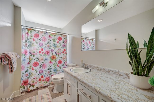Full bathroom with curtained shower, vanity, and toilet | Image 30