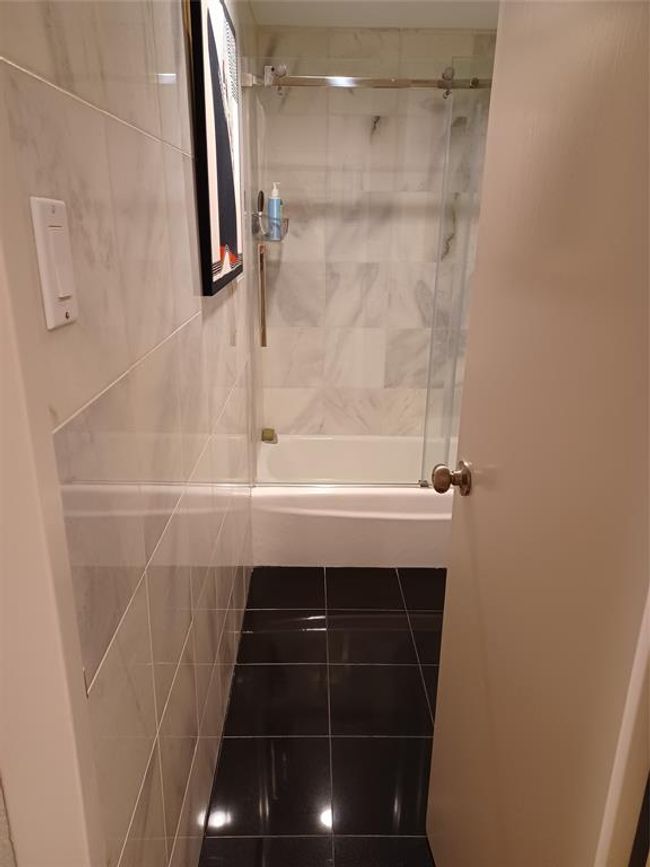 Standing with the vanity at your back and looking down the hallway toward the living room/dining room. | Image 15
