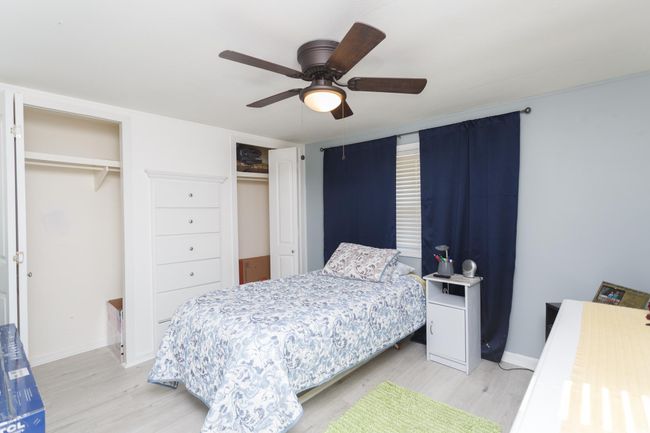Bedroom featuring light wood-style flooring, baseboards, and multiple closets | Image 25