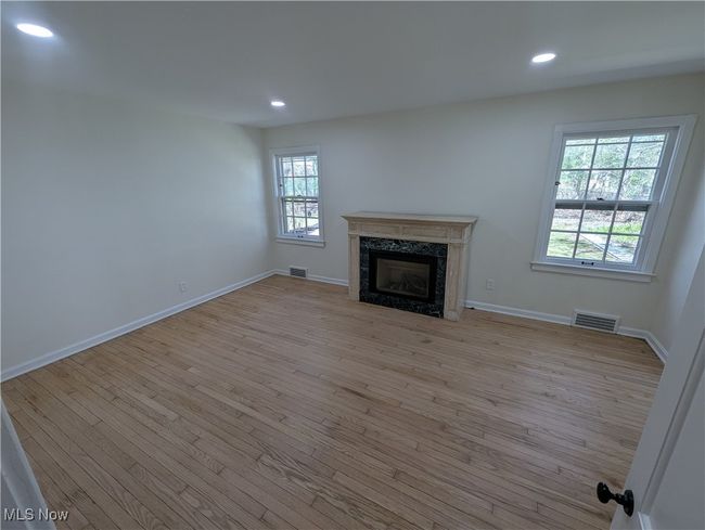 Unfurnished living room featuring a premium fireplace, recessed lighting, baseboards, and wood finished floors | Image 20