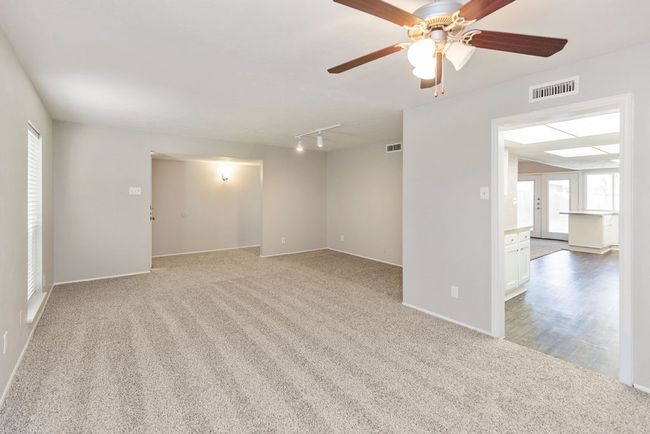 Carpeted spare room with baseboards, ceiling fan, visible vents, and track lighting | Image 4