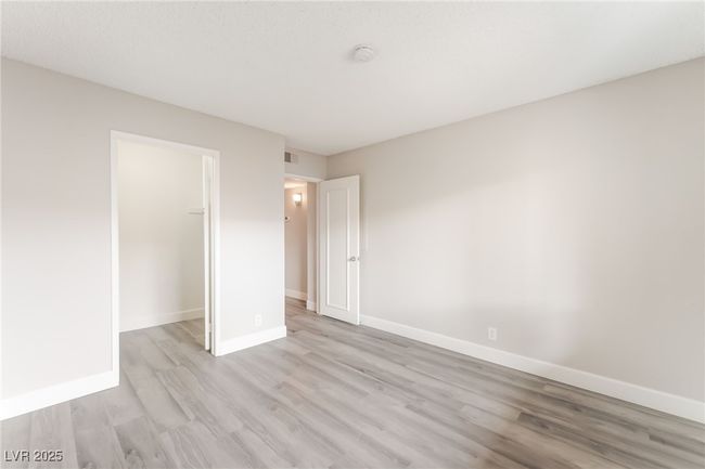 Unfurnished bedroom featuring light wood finished floors, a closet, and a walk in closet | Image 21