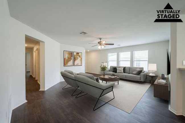 Living room featuring dark wood-type flooring, a ceiling fan, and baseboards | Image 4