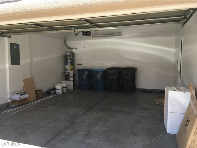 Garage with a garage door opener, secured water heater, and electric panel | Image 31