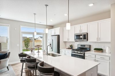 (Photo of decorated model, actual home's finishes will vary) The spacious kitchen features a large center island, quartz countertops, under mount sink, recessed lighting, LVP wood floors, stainless appliances and more! | Image 2