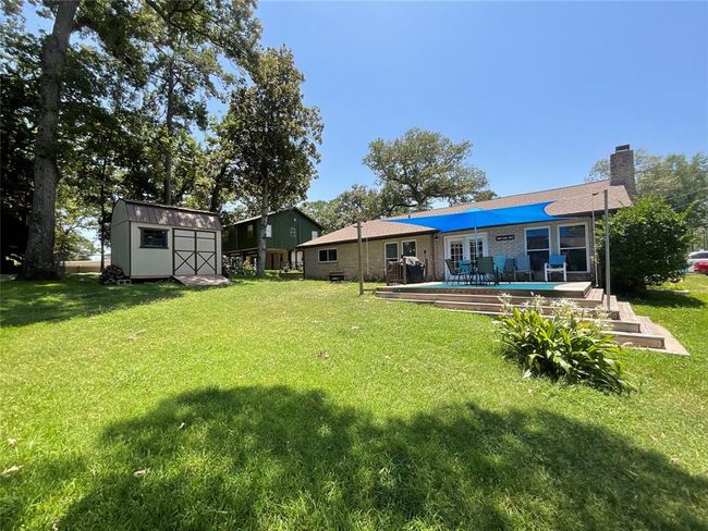 Side yard with large deck for entertaining and great views of the cove. Storage building conveys. | Image 5