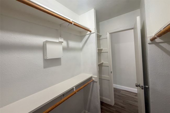 Walk in closet featuring dark wood-style flooring | Image 21