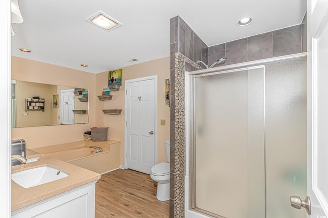 Full bath with a shower stall, vanity, wood finished floors, and recessed lighting | Image 17