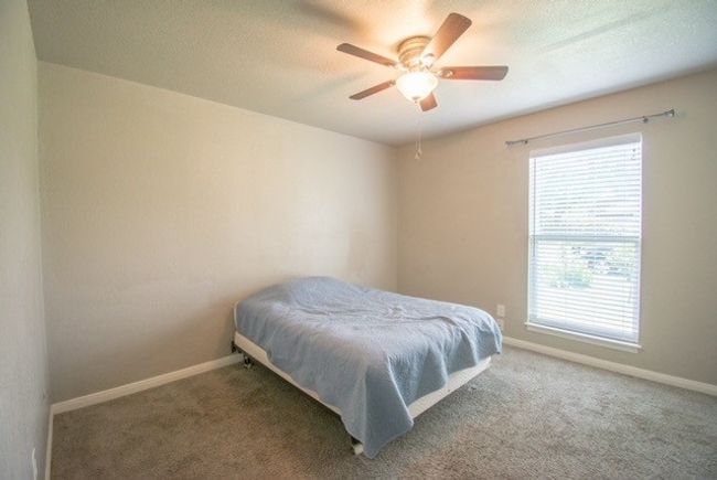 Bedroom featuring baseboards, carpet flooring, a textured ceiling, and ceiling fan | Image 10