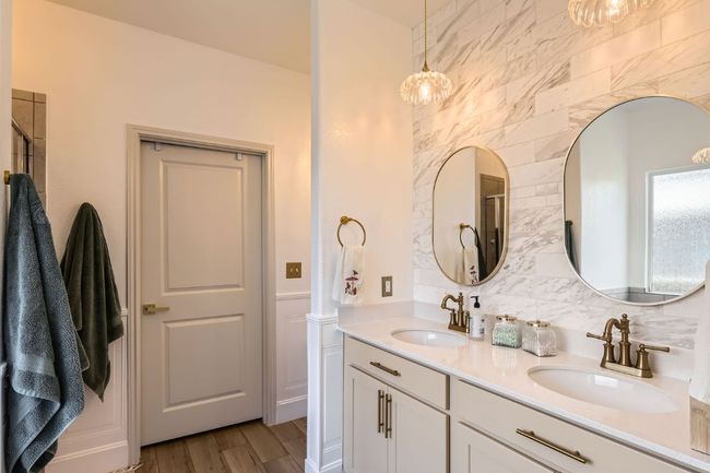 Full bathroom featuring double vanity, wood finished floors, tasteful backsplash, and a shower with shower door | Image 16