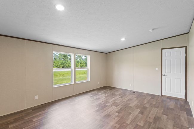 Spare room featuring wood finished floors, recessed lighting, crown molding, and a decorative wall | Image 21