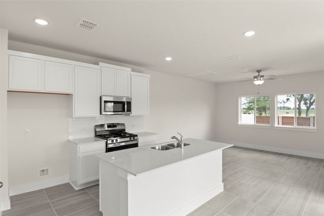 Kitchen with a sink, stainless steel appliances, baseboards, white cabinetry, and visible vents | Image 14