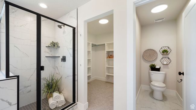 Full bathroom featuring a walk in closet, a marble finish shower, marble look tile flooring, and recessed lighting | Image 22
