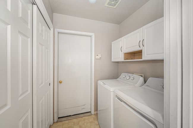 Separate utility room with full size washer and dryer connections. Storage closet and built-in cabinets. Door leads to garage. There is a pocket door to close off kitchen. Washer and Dryer will convey with purchase. | Image 6