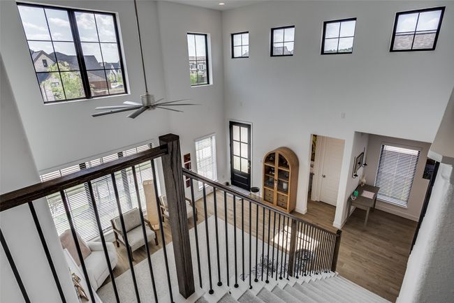 Stairs with wood finished floors, ceiling fan, and a high ceiling | Image 7