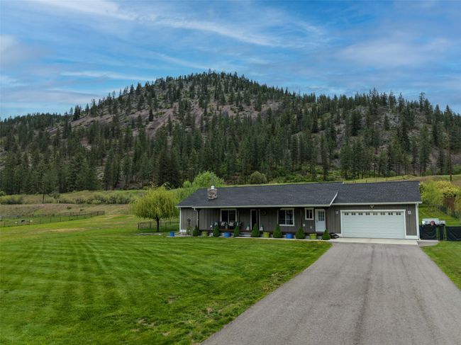 View of front of property with a garage, a front lawn, and a forest view | Image 48
