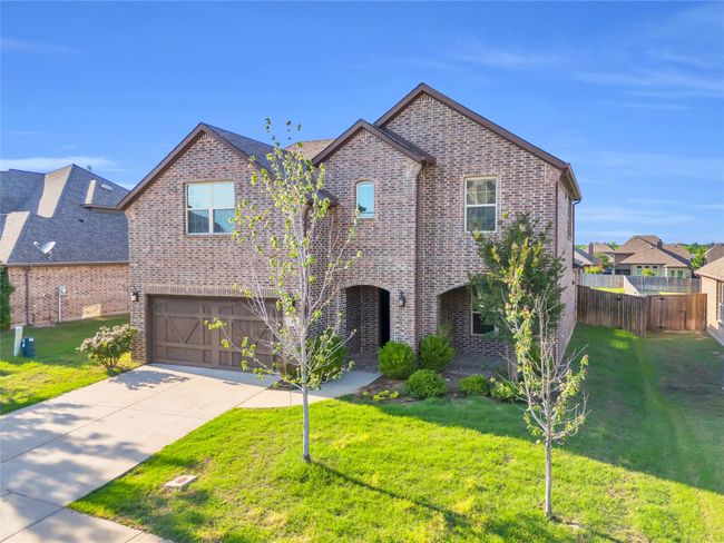 View of front facade with brick siding, an attached garage, and concrete driveway | Image 26