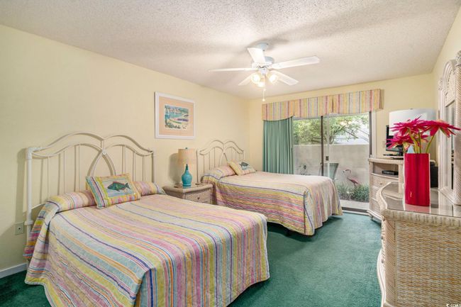 Soft carpeted bedroom with a ceiling fan, access to private patio. | Image 14