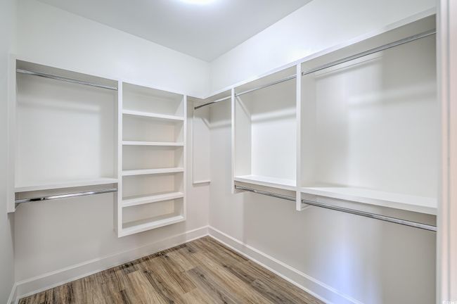 Walk in closet with light wood-style floors | Image 14
