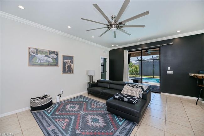 Living area featuring crown molding, light tile patterned flooring, baseboards, recessed lighting, and a ceiling fan | Image 4