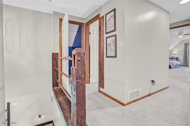 Hall with carpet flooring, visible vents, and baseboards | Image 23