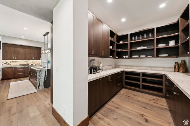 Kitchen with dark brown cabinets, open shelves, light wood-style floors, recessed lighting, and tasteful backsplash | Image 15