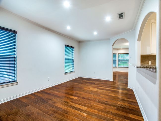 Unfurnished room with visible vents, arched walkways, dark wood finished floors, and ornamental molding | Image 6