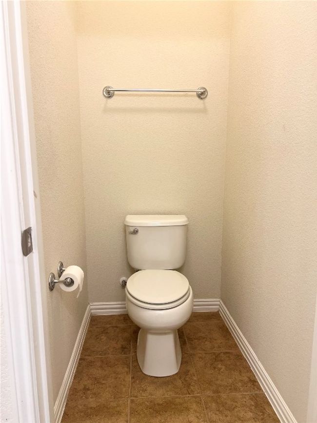 Bathroom featuring toilet, baseboards, and tile patterned floors | Image 12