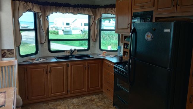 Kitchen. Full size refrigerator. Lake view when doing dishes. City water and sewer. | Image 11