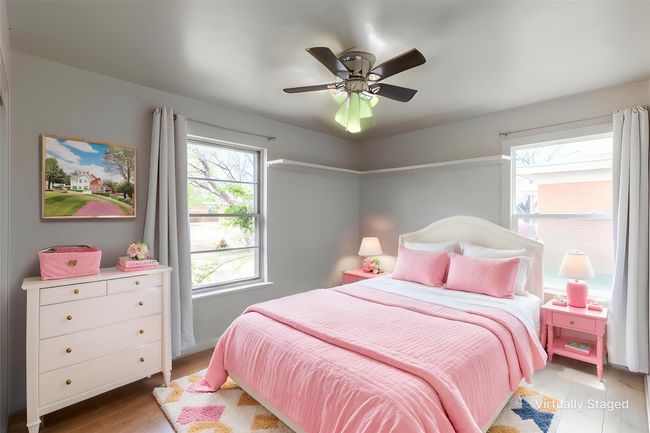 Bedroom featuring multiple windows, wood finished floors, and a ceiling fan | Image 9