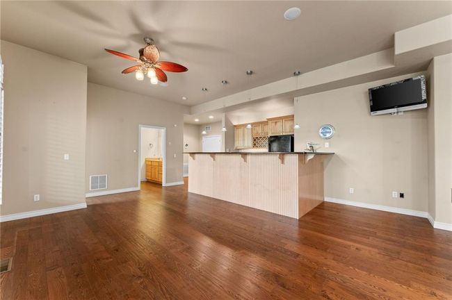 Unfurnished living room featuring a ceiling fan, visible vents, baseboards, and dark wood finished floors | Image 38
