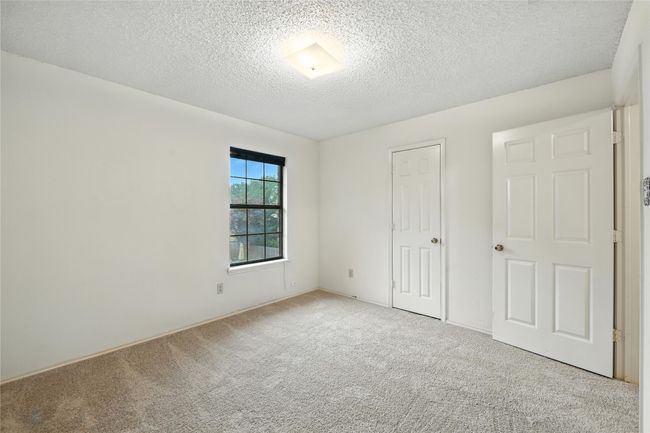 Unfurnished bedroom featuring carpet flooring, a textured ceiling, and a closet | Image 28