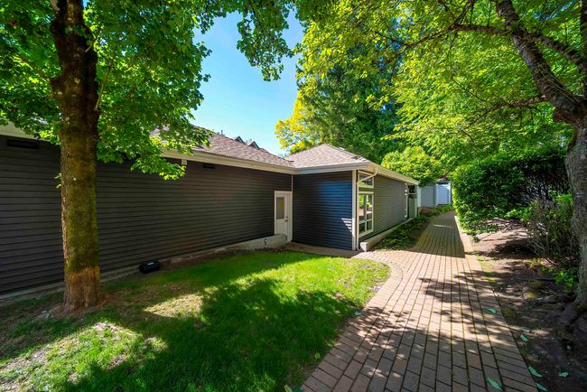 Rear view of property featuring a lawn and a shingled roof | Image 32